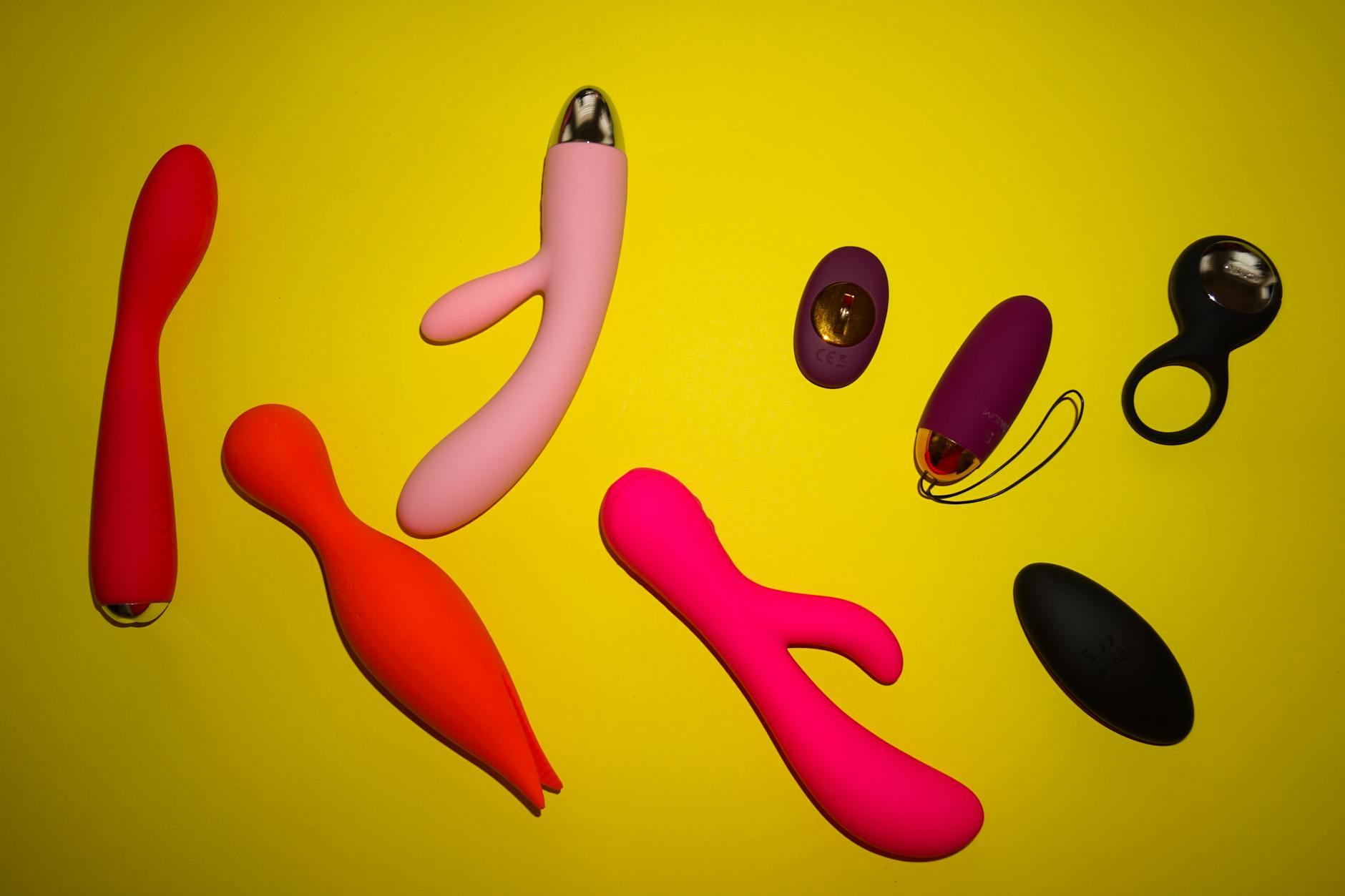 Vibrant arrangement of lemon-colored and other sex toys on a bright yellow surface