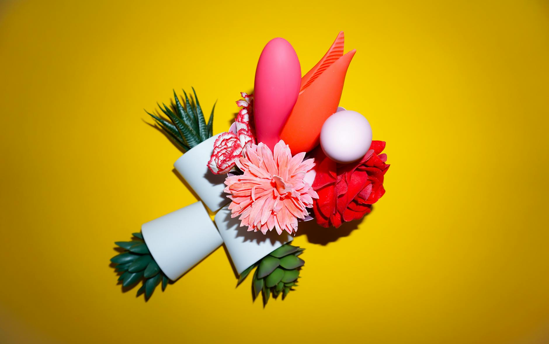 Colorful arrangement of flowers and abstract objects on a bright yellow background representing openness and variety
