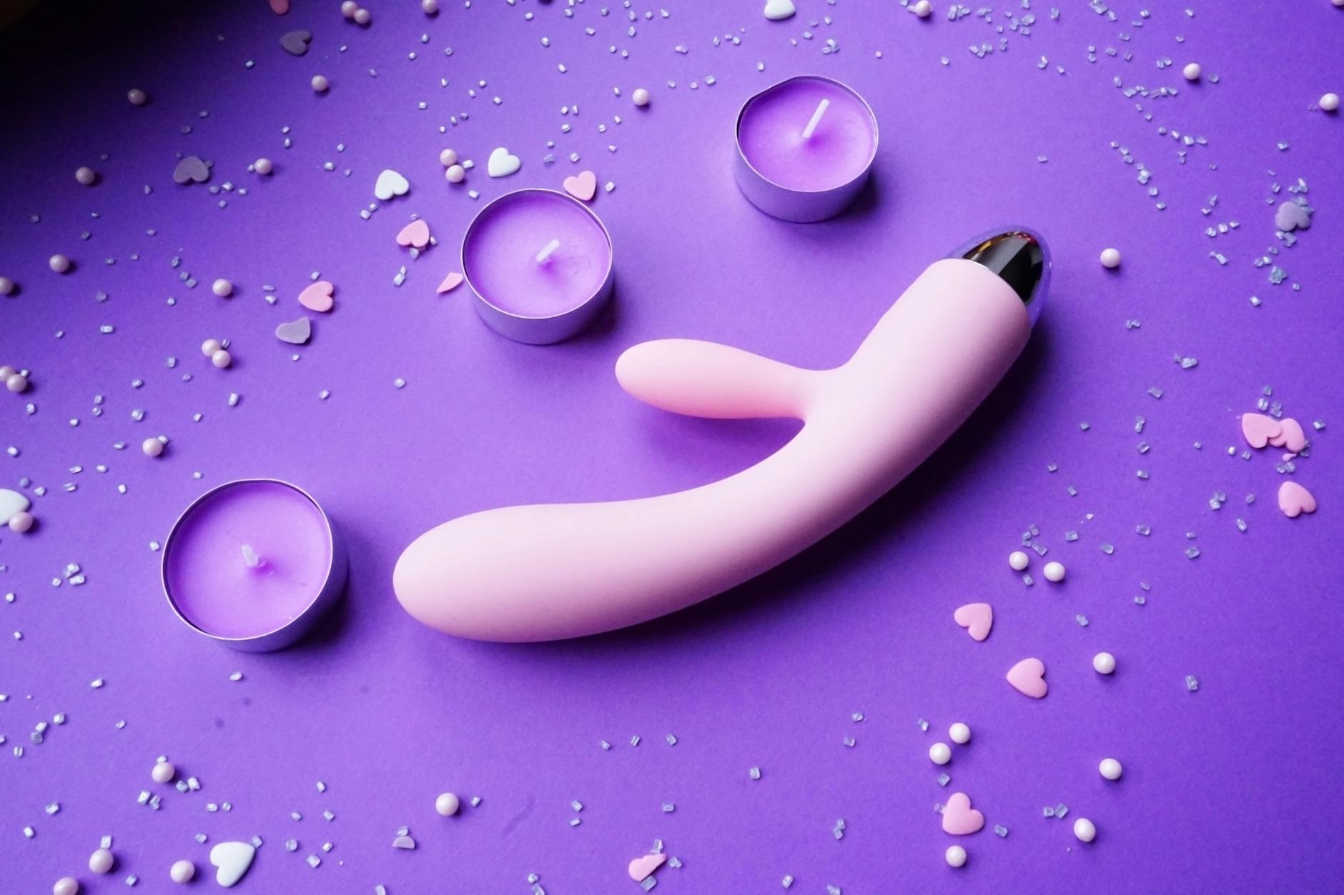 Yellow silicone vibrator surrounded by peeled bananas on a yellow background